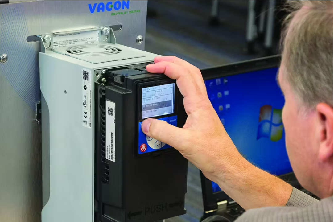 Technician programming a VACON variable frequency drive (VFD) via keypad